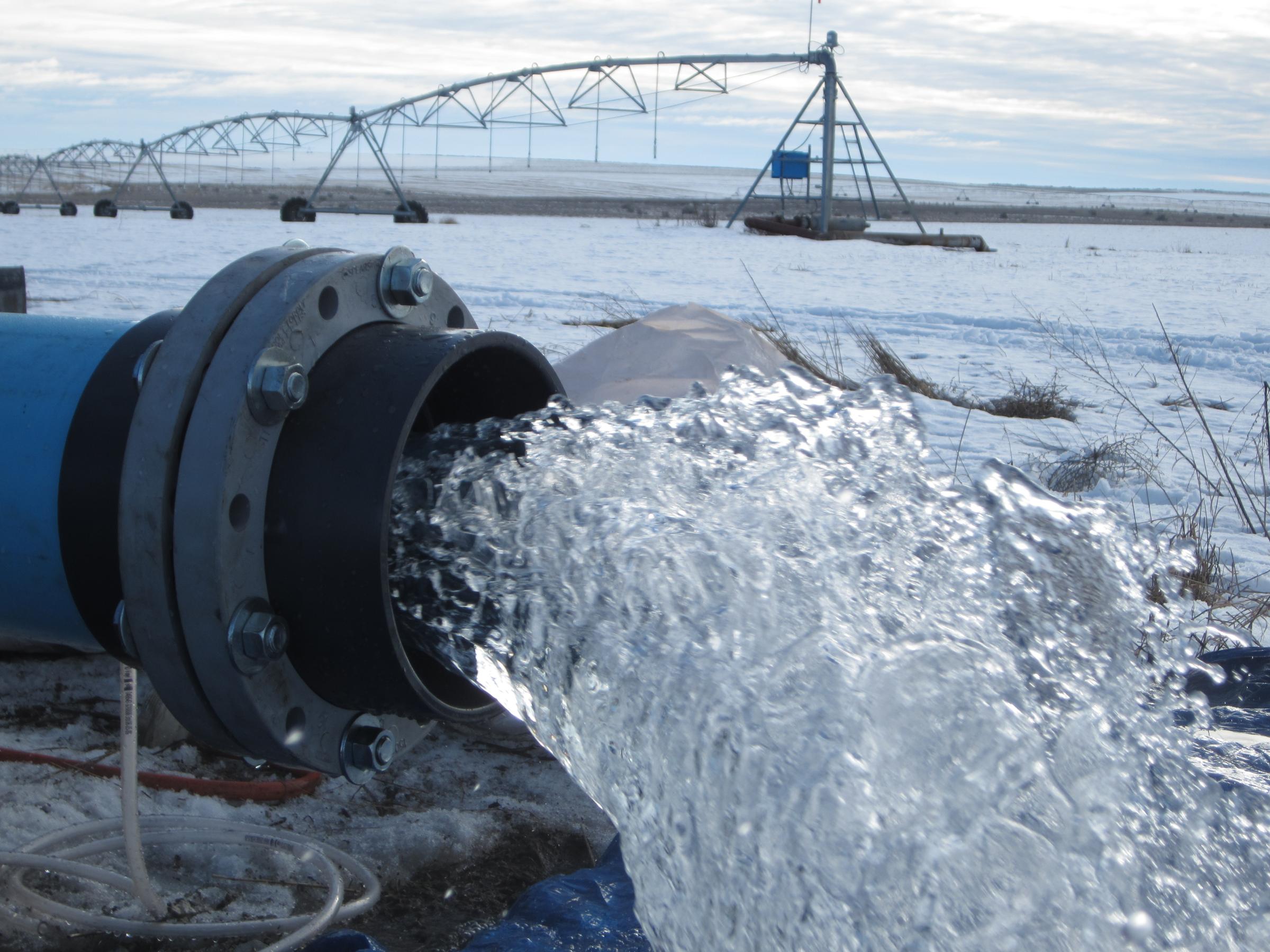 Water flowing from a pipe in a frozen landscape